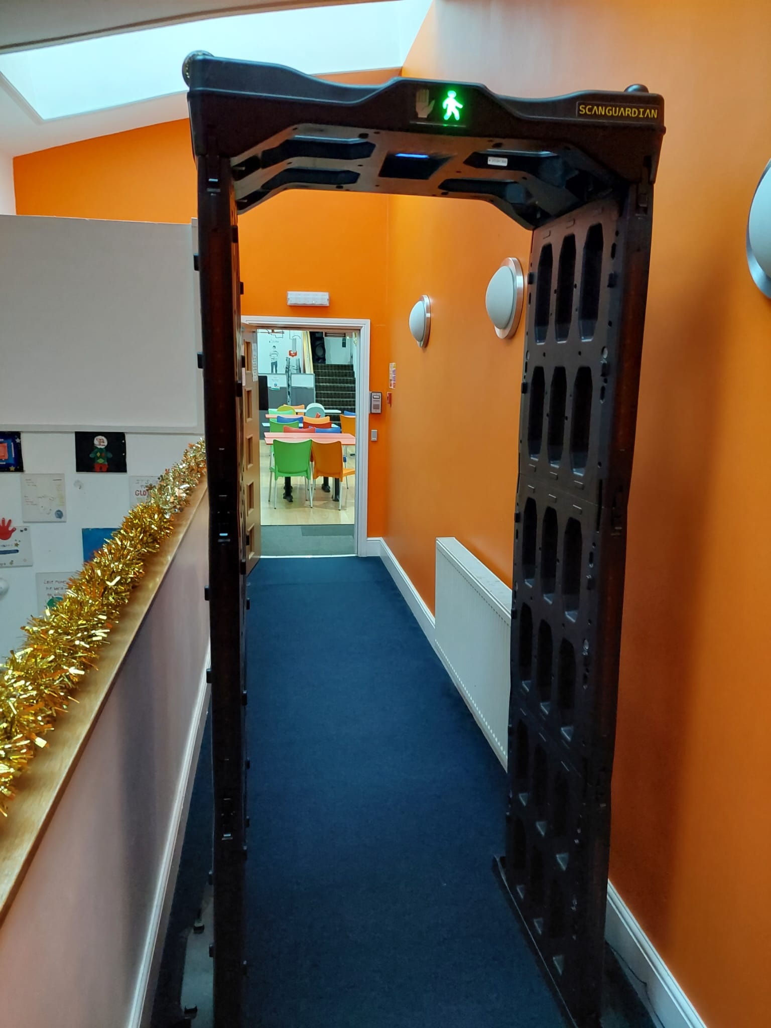 ScanGuardian arch installed in a school corridor with bright orange walls